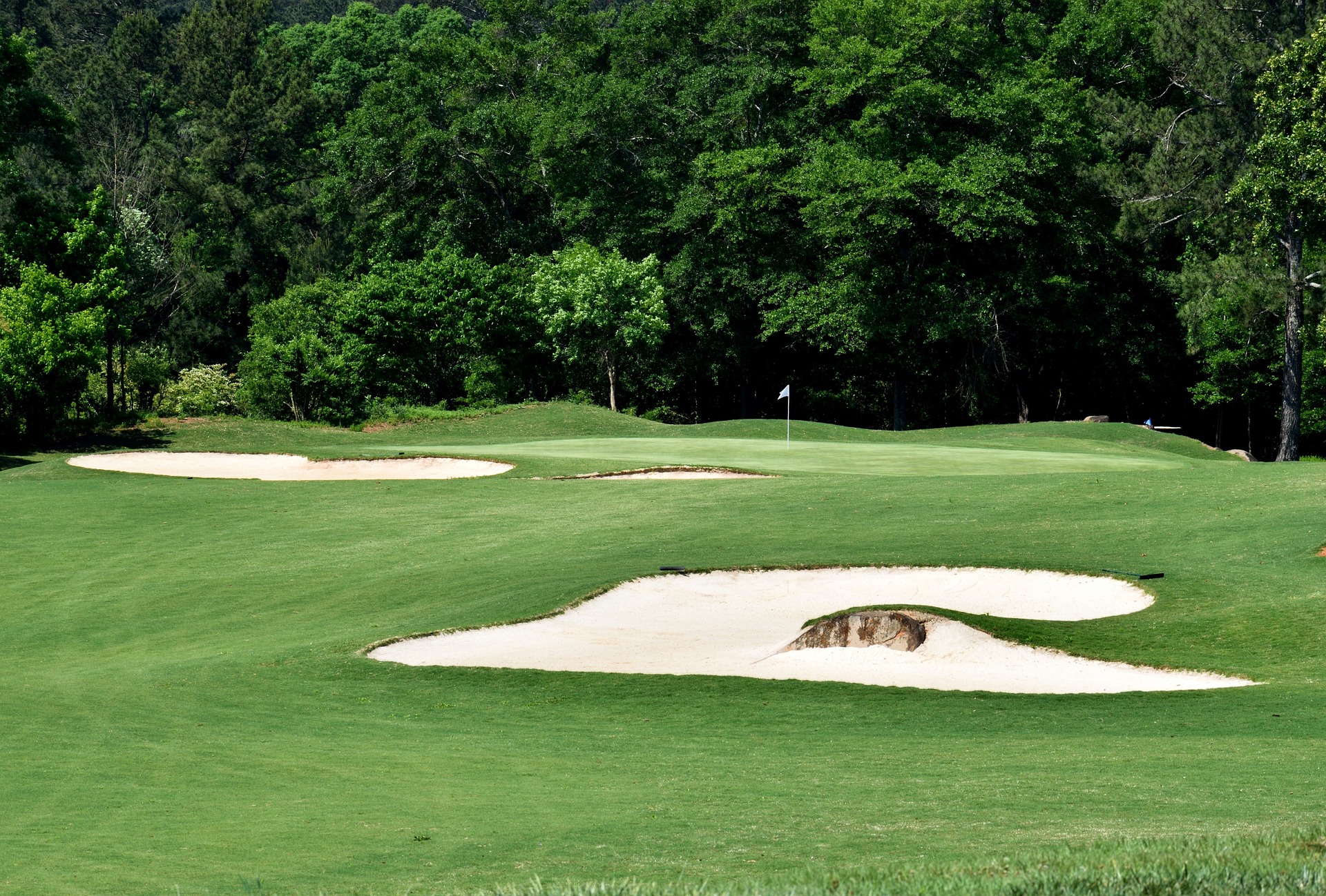 Photo of a golf course with two sand traps around the green.