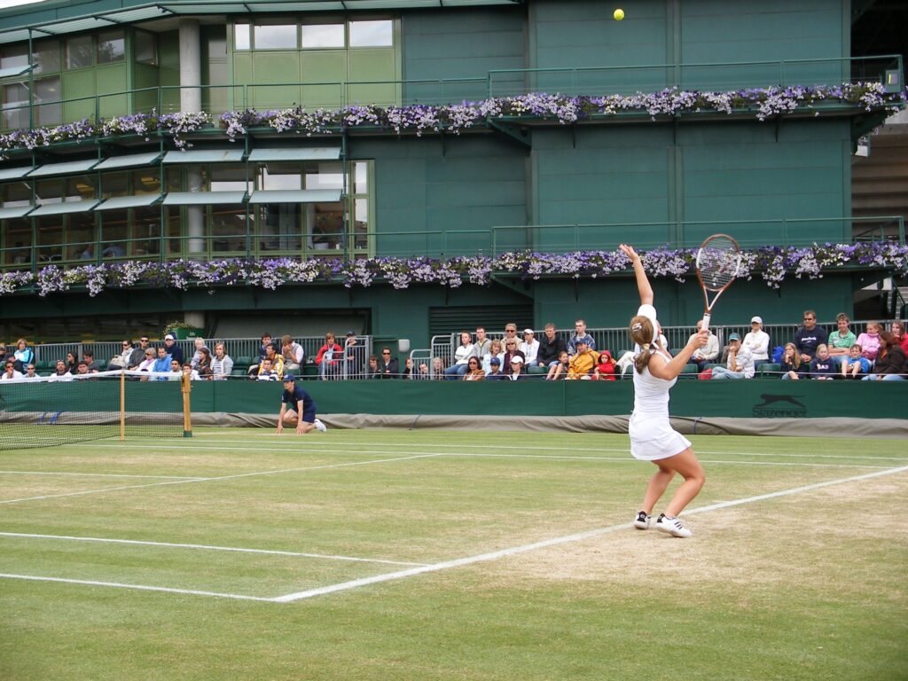 Woman playing tennis on grass court. Wimbledon betting tips will be important for the women's side of the bracket. 